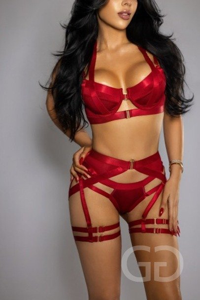 Melissa in a red harness lingerie set against a grey backdrop
