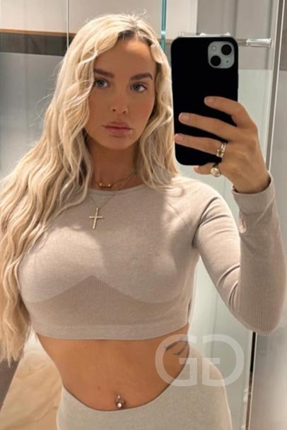 Lulu, tall blonde London escort, mirror selfie in a beige crop top