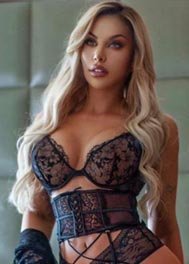 Charlie thumbnail - black lace bra and corset against a padded wall